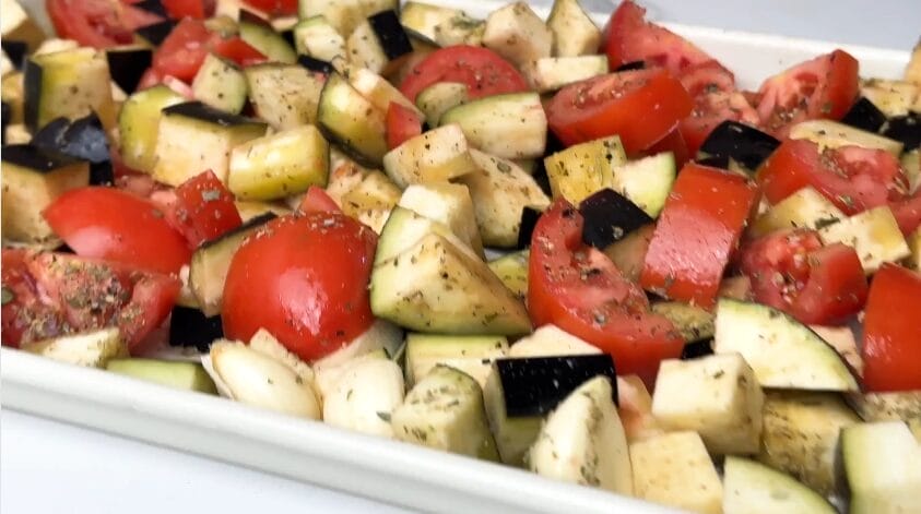 chopped and seasoned tomatoes, eggplants and garlic on baking tray