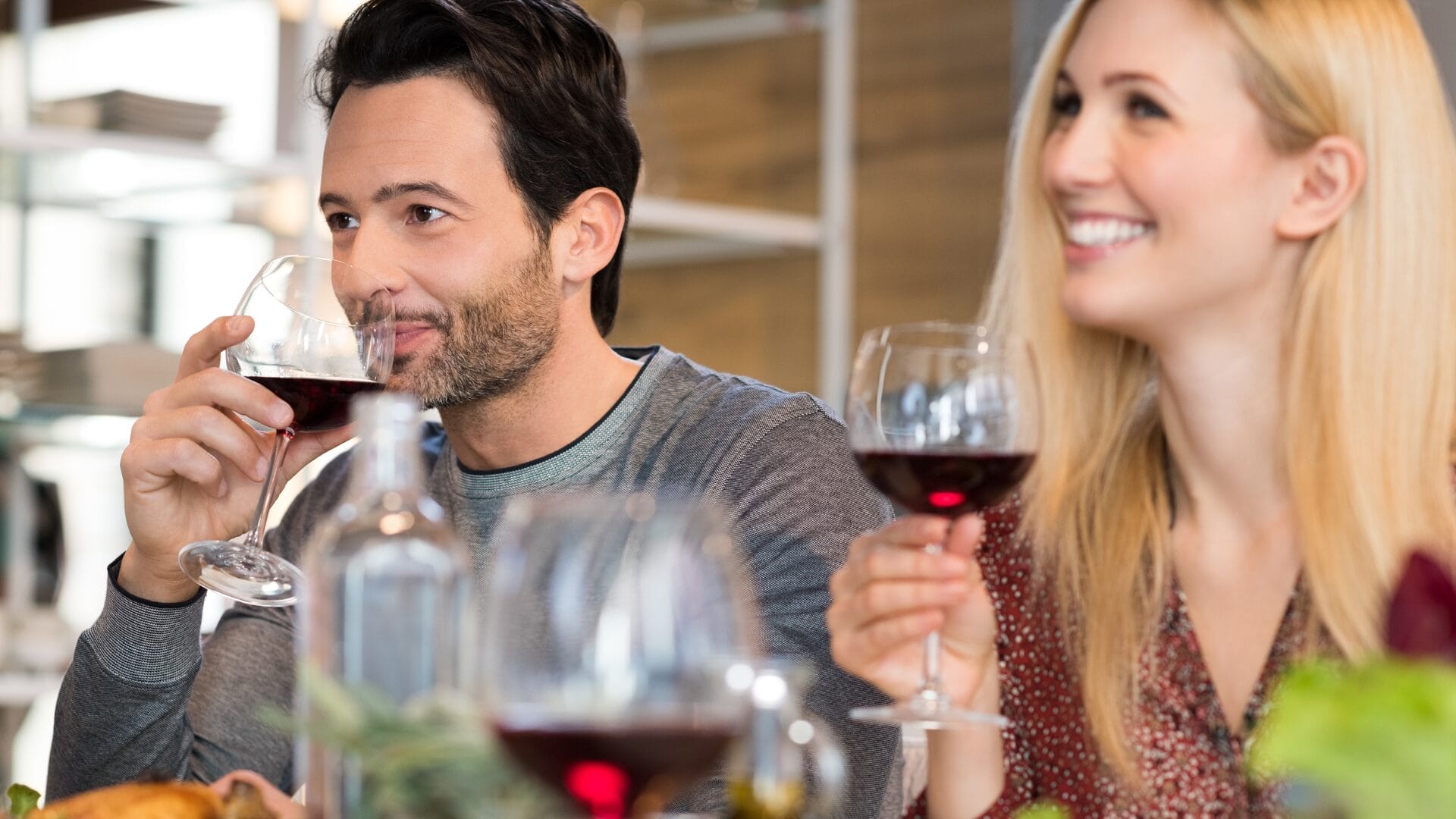 a man and woman drinking a glass of red wine