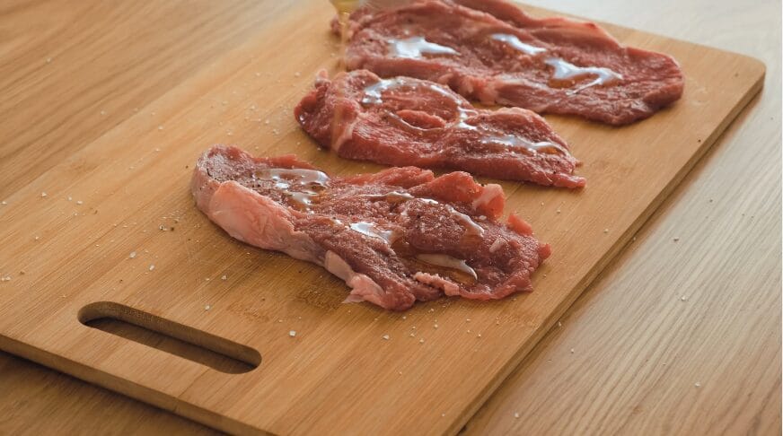 seasoned steaks on a cutting board