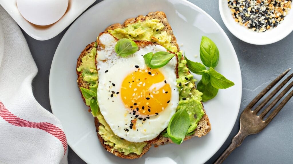 a plate of food with a fried egg on top of avocado toast