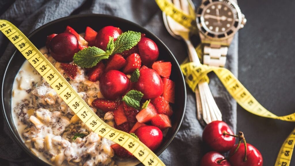 smoothie bol with cherries and strawberries and a measuring tape