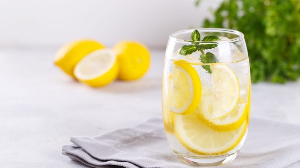 a glass of water with lemons and mint