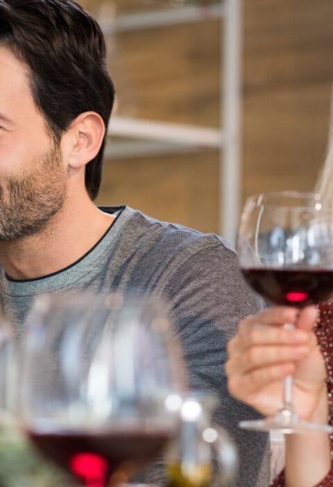 a man and woman drinking a glass of red wine