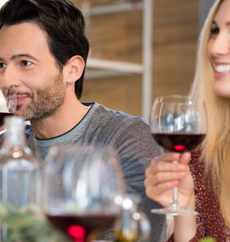 a man and woman drinking a glass of red wine