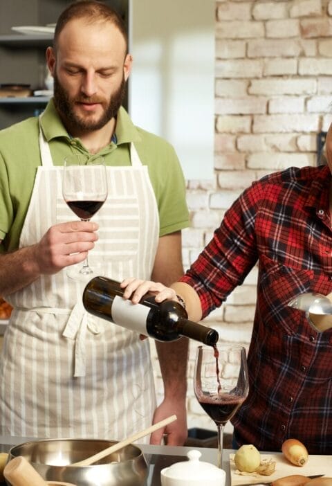 couple drinking and pouring wine in the kitchen red wine