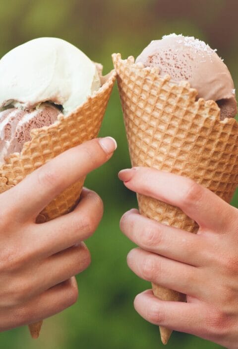 two hands holding ice cream cones