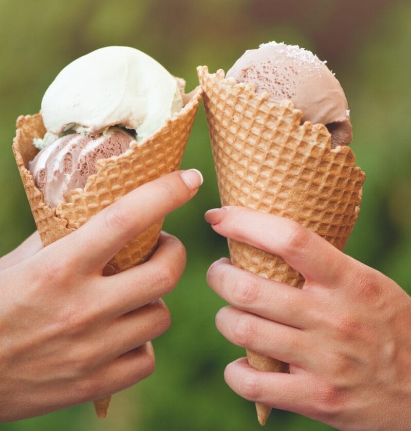 two hands holding ice cream cones