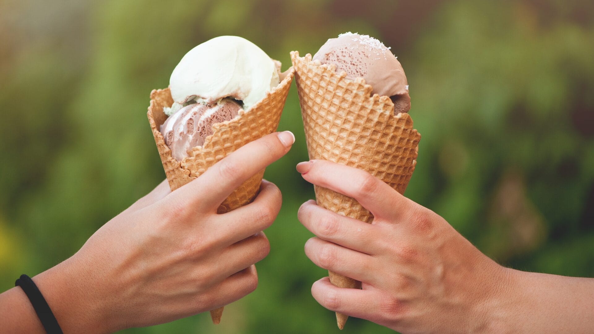 two hands holding ice cream cones