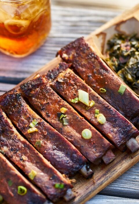 barbecue ribs on a plate with collard greens and macaroni and cheese