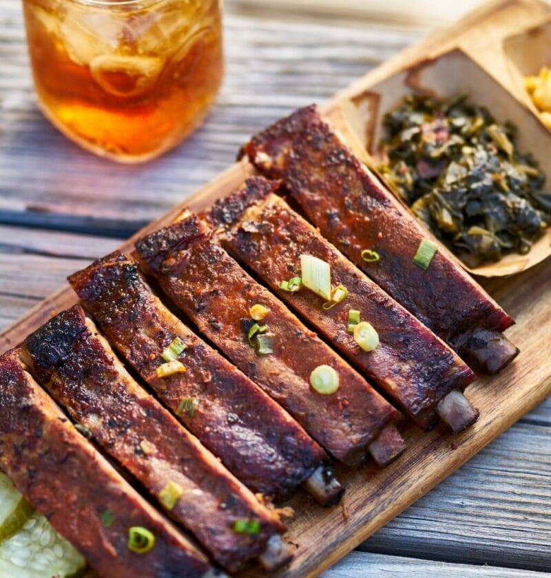 barbecue ribs on a plate with collard greens and macaroni and cheese