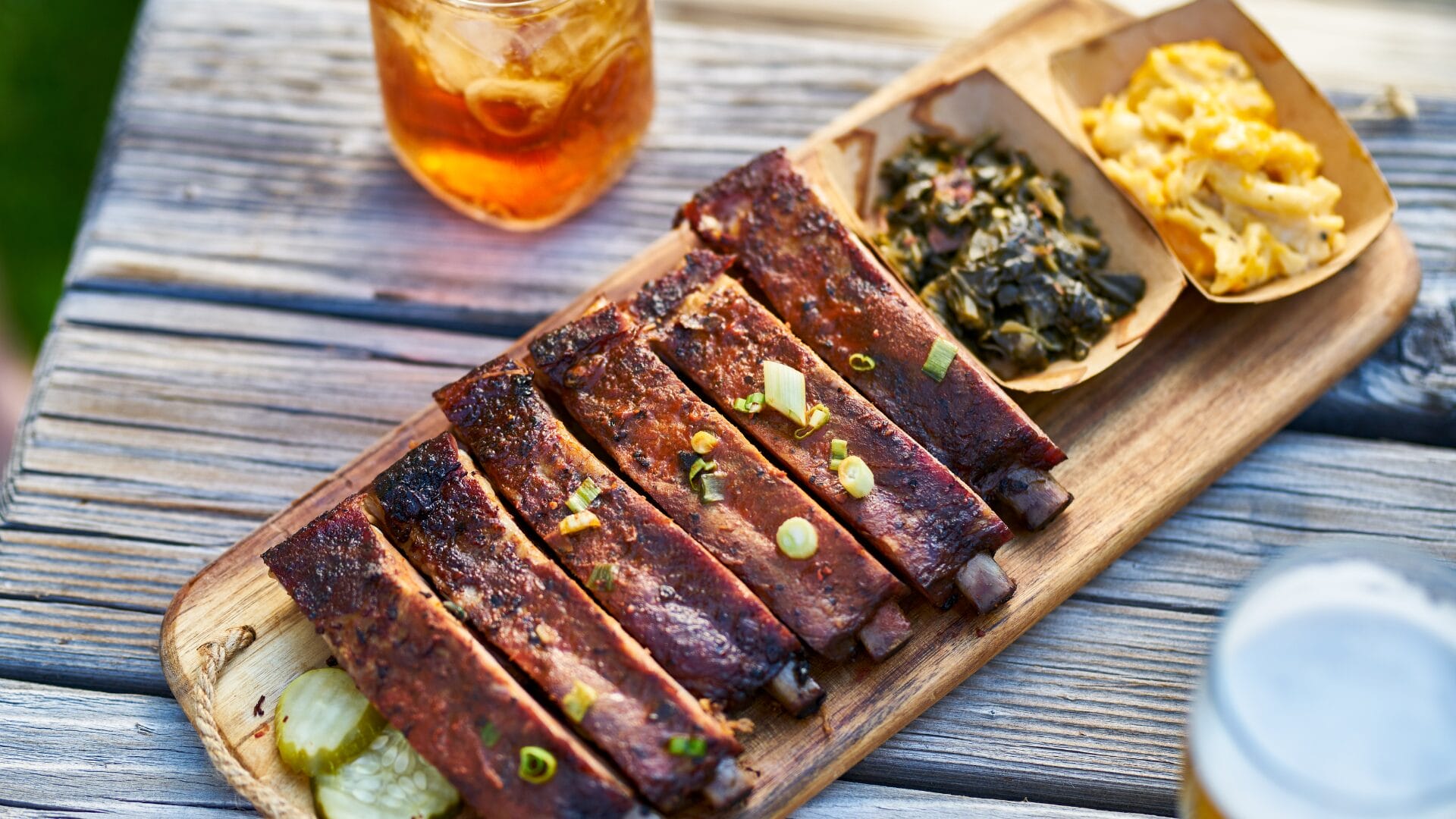 barbecue ribs on a plate with collard greens and macaroni and cheese